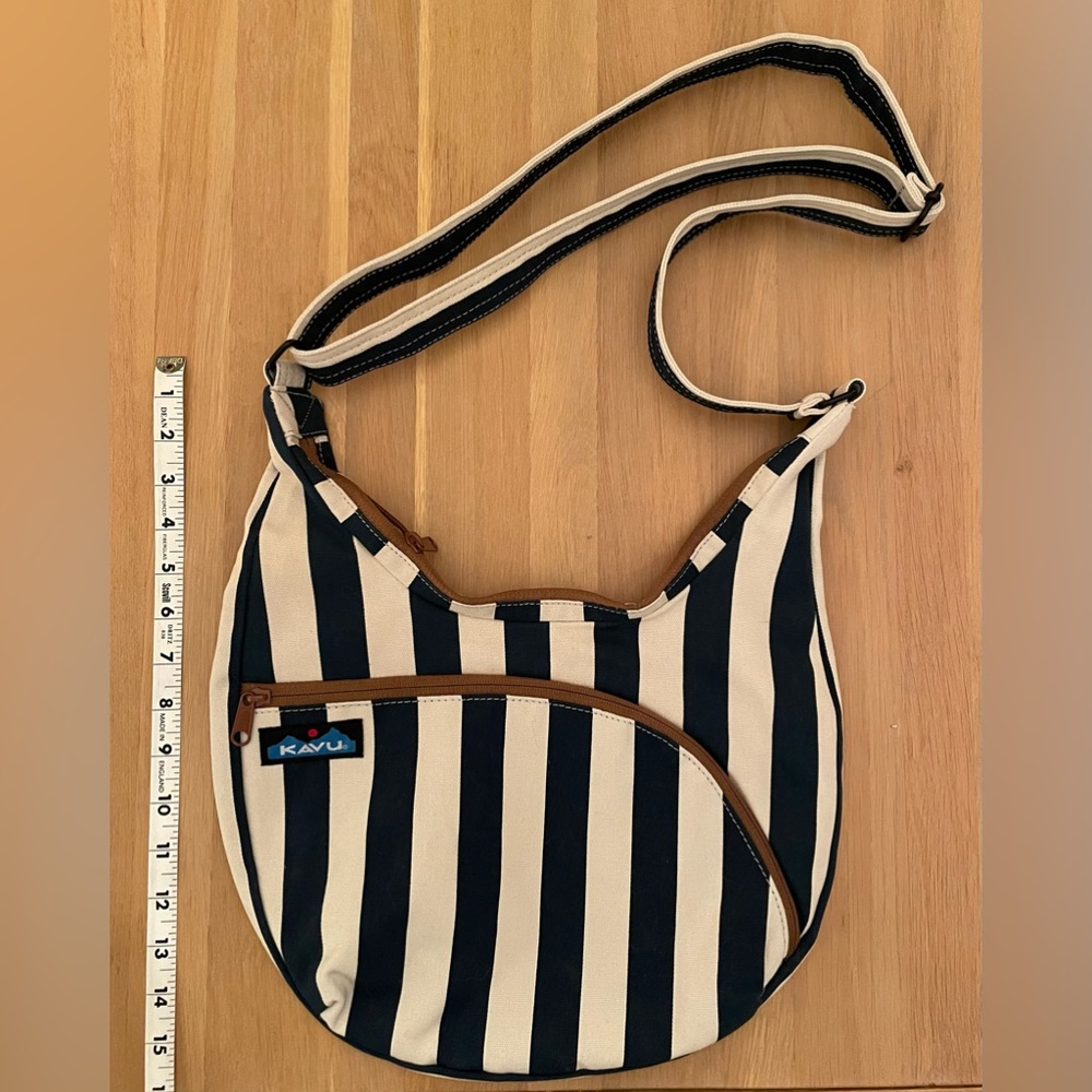 Navy blue striped cross body Kavu bag with brown zipper and gold interior